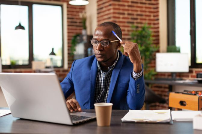 homme en réflexion devant son pc